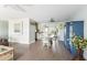 Open-concept dining area featuring wood-look floors, a dining table with seating, and a blue cabinet for storage at 2545 Geneva Rd, Venice, FL 34293