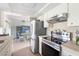 Modern kitchen with stainless steel appliances, light cabinetry, and view to the dining area, with modern tile backsplash at 2545 Geneva Rd, Venice, FL 34293