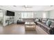 Spacious living room with a large leather sectional, modern ceiling fan, and bright windows, perfect for relaxing at 2545 Geneva Rd, Venice, FL 34293