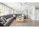 Bright living room featuring a comfortable leather sofa, a modern ceiling fan, and lots of natural light at 2545 Geneva Rd, Venice, FL 34293