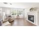 Bright living room with a decorative fireplace, wood floors, and large windows for natural light and views at 2545 Geneva Rd, Venice, FL 34293
