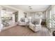 Inviting living room features neutral tones, wood floors, and plenty of natural light from sliding doors and windows at 2545 Geneva Rd, Venice, FL 34293