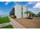 Well-maintained condo building featuring a stunning beach view with a vibrant green lawn area at 2820 N Beach Rd # 101, Englewood, FL 34223