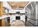 Modern kitchen featuring white cabinets, stainless steel appliances, and rustic wood accents at 2820 N Beach Rd # 101, Englewood, FL 34223