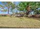 Large, grassy backyard with mature trees and a wooden fence for added privacy at 35 Michigan Ave, Englewood, FL 34223