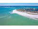 Sweeping aerial shot showcasing beachfront homes and crystal-clear turquoise waters meeting a white sandy shore at 36 Seawatch Dr, Boca Grande, FL 33921