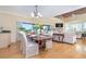 A formal dining room featuring hardwood floors, chandelier, and sliders leading to a screened lanai at 36 Seawatch Dr, Boca Grande, FL 33921