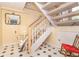 Bright entryway with staircase, chairlift, black and white tile, mirror, and red rocking chair at 36 Seawatch Dr, Boca Grande, FL 33921