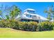 Beautiful two-story home with a metal roof, complemented by lush greenery and a manicured lawn at 36 Seawatch Dr, Boca Grande, FL 33921