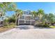 Beautiful two-story home featuring lush landscaping, a brick driveway, and a spacious two-car garage at 36 Seawatch Dr, Boca Grande, FL 33921