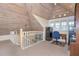 View of loft with wood-paneled ceiling, file cabinets, desk, and staircase with white railing at 36 Seawatch Dr, Boca Grande, FL 33921