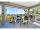 Screened-in patio featuring dining table, grill, and scenic views of the surrounding nature at 36 Seawatch Dr, Boca Grande, FL 33921