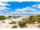 Expansive beach view with blue sky, palm trees and boardwalk, ideal for relaxation and recreation at 5000 Gasparilla Rd # Dc305, Boca Grande, FL 33921