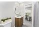 Well-lit bathroom featuring a modern vanity, a decorative mirror, and access to the hallway and shower at 5041 N Beach Rd # 1A And 1B, Englewood, FL 34223