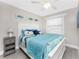 Charming bedroom bathed in soft light, features cozy nautical bedding and ceiling fan for added comfort at 5041 N Beach Rd # 1A And 1B, Englewood, FL 34223