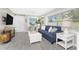 Living room featuring a comfortable sofa, television, and plenty of natural light through the windows at 5041 N Beach Rd # 1A And 1B, Englewood, FL 34223