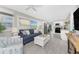 Inviting living room and kitchen featuring a comfortable sofa, open layout, and views through a window at 5041 N Beach Rd # 1A And 1B, Englewood, FL 34223