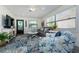 Bright living room featuring large windows, comfortable seating, and stylish coastal-themed decor at 5041 N Beach Rd # 1A And 1B, Englewood, FL 34223
