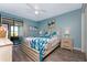 The main bedroom offers a bright and airy feel with a ceiling fan, coastal bedding, and sliding door access to a private balcony at 5041 N Beach Rd # 1A And 1B, Englewood, FL 34223