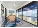 Charming sunroom with expansive views of the lake, featuring a ceiling fan and dining table at 5041 N Beach Rd # 1A And 1B, Englewood, FL 34223