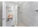 Bathroom showcasing a pebble stone shower floor, tiled walls, and a view into an adjoining room at 5041 N Beach Rd # 3A And 3B, Englewood, FL 34223
