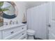 Bathroom featuring white vanity, round nautical mirror, toilet and shower with white curtain at 5041 N Beach Rd # 3A And 3B, Englewood, FL 34223