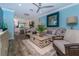 Coastal-style living room with wood floors, ceiling fan, and open access to the kitchen and dining area at 5041 N Beach Rd # 3A And 3B, Englewood, FL 34223