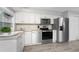 Updated kitchen with stainless steel appliances, light countertops, and wood grain floors at 5041 N Beach Rd # 4A And 4B, Englewood, FL 34223