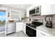 Modern kitchen with white cabinetry, stainless steel appliances, and granite countertops at 5041 N Beach Rd # 4A And 4B, Englewood, FL 34223