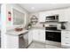 Kitchen with stainless steel appliances, white cabinets, and a view of the water at 5041 N Beach Rd # 4A And 4B, Englewood, FL 34223