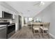 Open floor plan features kitchen open to dining area, updated stainless steel appliances, and wood floors at 5041 N Beach Rd # 4A And 4B, Englewood, FL 34223