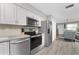 Updated kitchen with stainless steel appliances, light countertops, and wood grain floors at 5041 N Beach Rd # 4A And 4B, Englewood, FL 34223