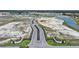 Primary-planned community entry featuring landscaped median and community under development with ponds and green spaces at 5132 Schubert Trl, North Port, FL 34287