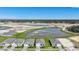 The aerial view showcases modern homes near a tranquil lake, highlighting community development and natural beauty at 5132 Schubert Trl, North Port, FL 34287