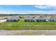 An aerial view shows new homes near a scenic pond, surrounded by lush green lawns at 5132 Schubert Trl, North Port, FL 34287