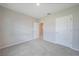 A bright, carpeted bedroom with neutral walls and a hallway view through the open doorway at 5132 Schubert Trl, North Port, FL 34287
