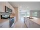 Modern kitchen featuring stainless steel appliances, white cabinetry and a view through to the backyard at 5132 Schubert Trl, North Port, FL 34287