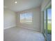 Cozy living room showcasing a window with a serene view and sliding glass door access to the outdoors at 5132 Schubert Trl, North Port, FL 34287