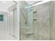 Beautifully tiled walk-in shower with glass enclosure and convenient built-in shelving for toiletries at 52 Golfview Ter, Rotonda West, FL 33947