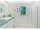 This bright bathroom features a white vanity, square sink and decorative mirror at 52 Golfview Ter, Rotonda West, FL 33947