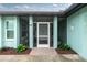 Charming covered front porch featuring decorative wall art and tasteful landscaping at 52 Golfview Ter, Rotonda West, FL 33947