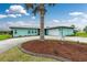 Beautiful turquoise home with a well-maintained front yard and a whimsical pelican statue at 52 Golfview Ter, Rotonda West, FL 33947