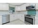 Kitchen featuring stainless appliances, white cabinets and a decorative tile backsplash at 52 Golfview Ter, Rotonda West, FL 33947