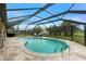 Beautiful kidney-shaped pool with a screened enclosure and flagstone patio surrounded by tropical landscaping at 52 Golfview Ter, Rotonda West, FL 33947
