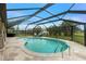 A screened-in pool area features a kidney shaped pool and stone patio with seating at 52 Golfview Ter, Rotonda West, FL 33947