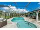 A screened-in pool area features a kidney shaped pool, stone patio, seating and an outdoor bar area at 52 Golfview Ter, Rotonda West, FL 33947