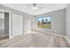 Bedroom featuring wood-look flooring, closet, ceiling fan, and large window at 5881 Talbrook Rd, North Port, FL 34287