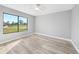 Bright bedroom featuring a ceiling fan, wood-look floors, and a large window offering a neighborhood view at 5881 Talbrook Rd, North Port, FL 34287