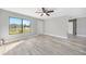 Bright living room features wood-look flooring, ceiling fan, and a large window offering a view of the neighborhood at 5881 Talbrook Rd, North Port, FL 34287