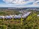 Breathtaking aerial view showcases yellow condos nestled in the serene, coastal landscape with ocean background at 6610 Gasparilla Pines Blvd # 111, Englewood, FL 34224